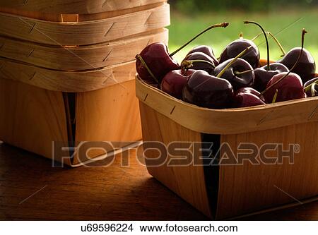 Basket full of cherries on wooden table View Large Photo Image Picture - Basket full of cherries on wooden table. Fotosearch
