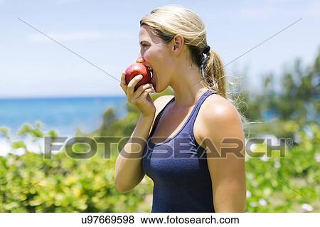 Blonde beautiful woman eating fresh apple View Large Photo Image Stock Photo - Blonde beautiful woman eating fresh apple. Fotosearch