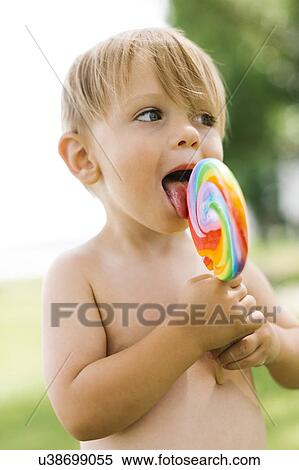 Stock Photography - Boy (2-3) licking lollipop. Fotosearch