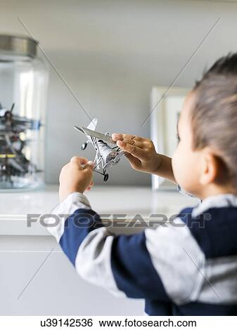 Stock Photograph - Boy (2-3) playing with model airplane. Fotosearch