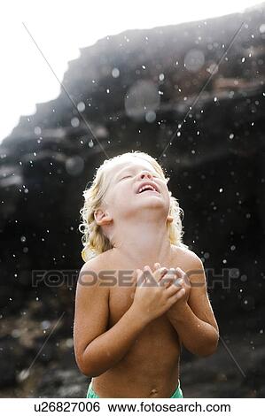 Stock Photograph - Boy (4-5) playing with rain. Fotosearch