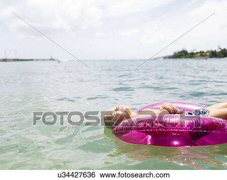 Boy (4-5) swimming on inflatable ring View Large Photo Image Stock Photograph - Boy (4-5) swimming on inflatable ring. Fotosearch