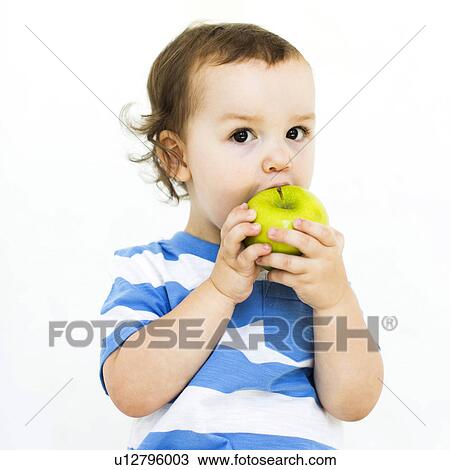 Boy (4-5) wearing t-shirt eating green apple View Large Photo Image Stock Image - Boy (4-5) wearing t-shirt eating green apple. Fotosearch