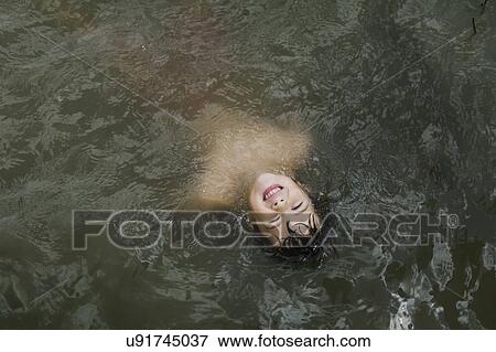 Boy (6-7) floating in lake View Large Photo Image Stock Photo - Boy (6-7) floating in lake. Fotosearch