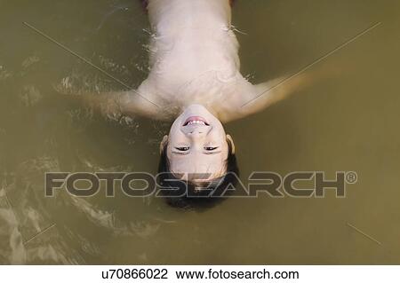 Boy (6-7) floating on water View Large Photo Image Stock Image - Boy (6-7) floating on water. Fotosearch