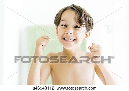 Stock Image - Boy (6-7) flossing teeth. Fotosearch