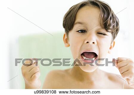 Stock Photo - Boy (6-7) flossing teeth. Fotosearch