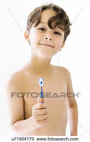 Boy (6-7) holding toothbrush View Large Photo Image Stock Image - Boy (6-7) holding toothbrush. Fotosearch