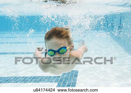 Picture - Boy (6-7) swimming in pool. Fotosearch