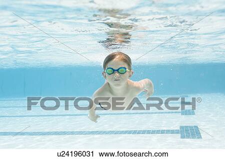 Boy (6-7) swimming in pool View Large Photo Image Stock Image - Boy (6-7) swimming in pool. Fotosearch