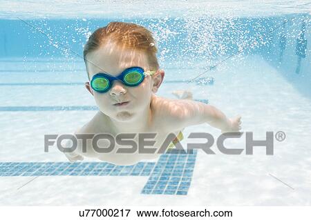 Stock Photo - Boy (6-7) swimming in pool. Fotosearch