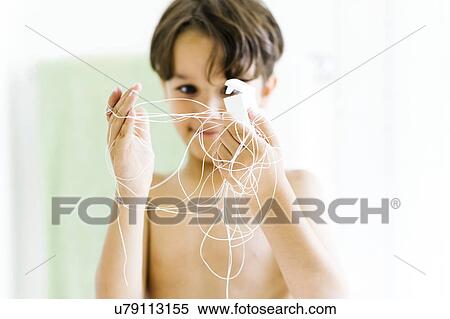 Boy (6-7) watching dental floss View Large Photo Image Stock Photography - Boy (6-7) watching dental floss. Fotosearch