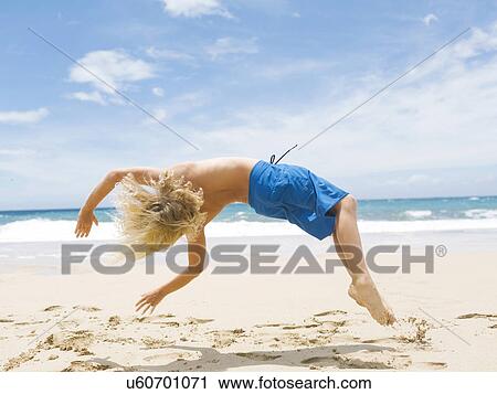 Boy (8-9) backfilling on beach View Large Photo Image Stock Image - Boy (8-9) backfilling on beach. Fotosearch
