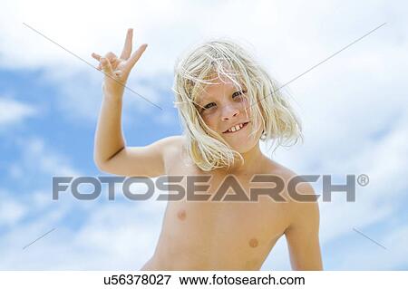 Boy (8-9) showing peace sign against blue sky View Large Photo Image Stock Photo - Boy (8-9) showing peace sign against blue sky. Fotosearch