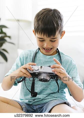 Boy (8-9) watching camera with curiosity View Large Photo Image Stock Image - Boy (8-9) watching camera with curiosity. Fotosearch