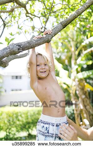 Stock Photography - Boy hanging on tree. Fotosearch