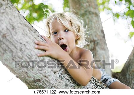 Stock Image - Boy sitting on tree. Fotosearch