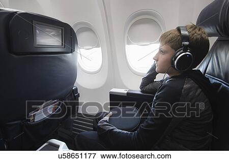 Boy watching tv in aero plane View Large Photo Image Stock Photo - Boy watching tv in aero plane. Fotosearch