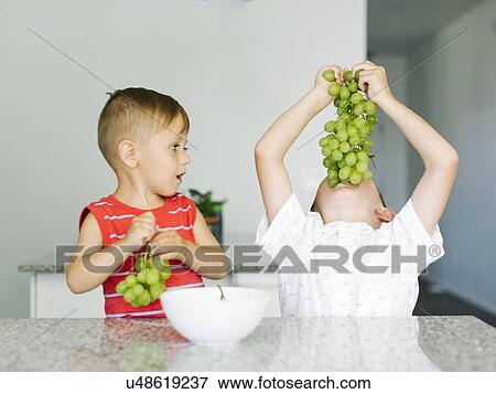Boys (2-3, 6-7) eating white grapes View Large Photo Image Stock Photo - Boys (2-3, 6-7) eating white grapes. Fotosearch