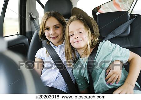 Stock Photo - Brother (6-7) and sister ( 8-9) sitting in car. Fotosearch
