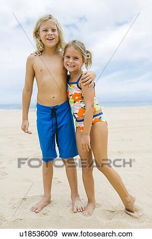Brother (8-9) and sister (6-7) embracing on beach View Large Photo Image Stock Photo - Brother (8-9) and sister (6-7) embracing on beach. Fotosearch