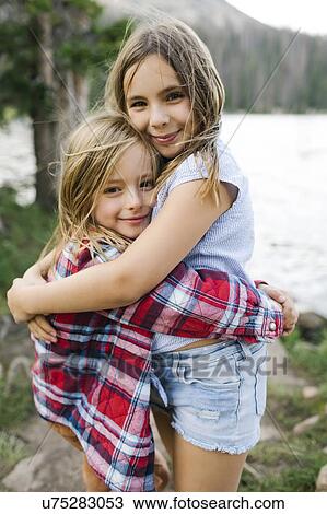 Stock Image - Brother and sister hugging in forest. Fotosearch