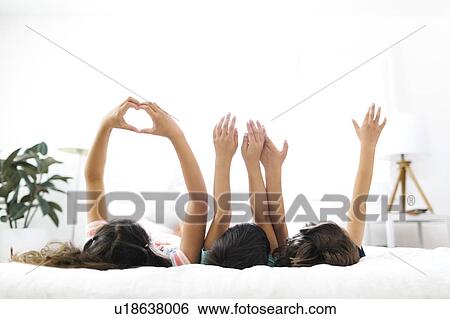 Brothers ( 6-7, 8-9 ) and sister ( 10-11 ) lying on bed and gesturing View Large Photo Image Stock Photograph - Brothers ( 6-7, 8-9 ) and sister ( 10-11 ) lying on bed and gesturing. Fotosearch