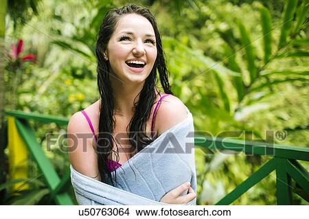 Picture - Caribbean Islands, Saint Lucia, Woman with wet hair wrapped in towel with lush foliage in background. Fotosearch