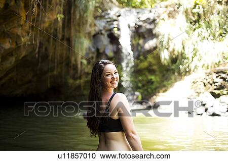 Stock Image - Caribbean Islands, Saint Lucia, Woman by waterfall. Fotosearch