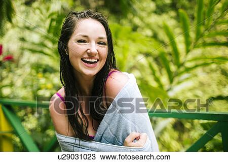 Stock Image - Caribbean Islands, Saint Lucia, Woman with wet hair wrapped in towel with lush foliage in background. Fotosearch