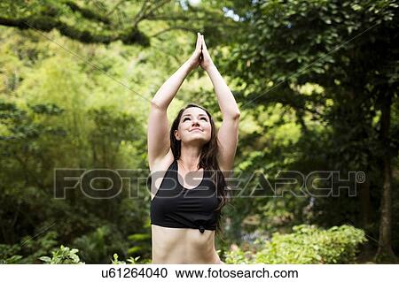 Stock Image - Caribbean Islands, Saint Lucia, woman doing yoga exercises in open air. Fotosearch