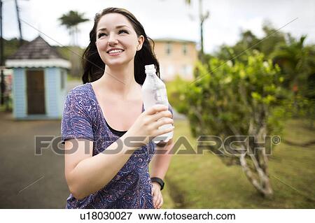 Stock Photo - Caribbean Islands, Saint Lucia, Woman holding bottle. Fotosearch