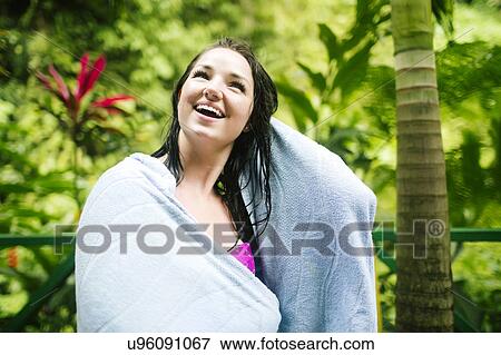 Stock Photo - Caribbean Islands, Saint Lucia, Woman with wet hair wrapped in towel with lush foliage in background. Fotosearch