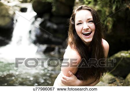Stock Photo - Caribbean Islands, Saint Lucia, Women by waterfall bending and hugging self. Fotosearch