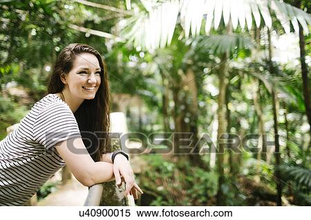 Stock Photography - Caribbean Islands, Saint Lucia, Women leaning on fence in tropical forest. Fotosearch