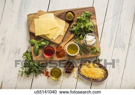 Cheese, herbs and spices on cutting board View Large Photo Image Stock Image - Cheese, herbs and spices on cutting board. Fotosearch