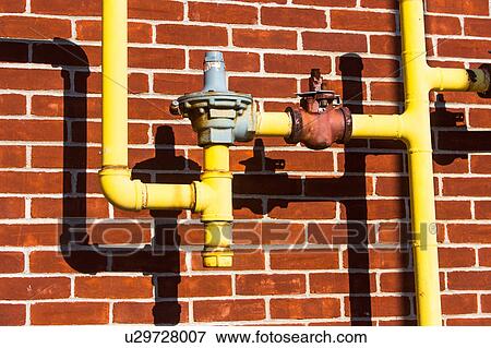 Stock Photo - Close up of pipes in front of brick wall. Fotosearch