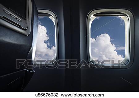 Stock Image - Clouds behind airplane window. Fotosearch