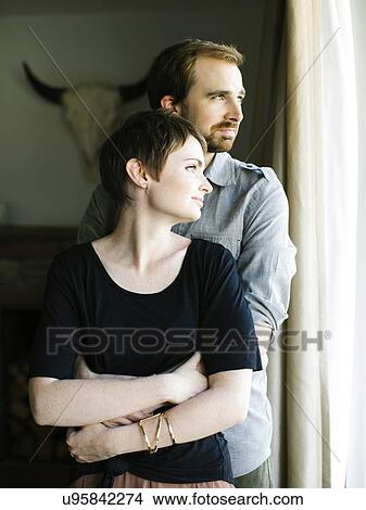 Couple looking through window View Large Photo Image Picture - Couple looking through window. Fotosearch