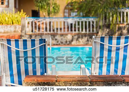 Stock Photography - Cuba, Havana, Deck chairs by swimming pool. Fotosearch