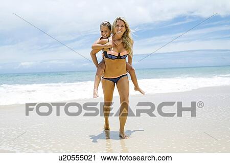 Daughter (6-7) playing with mother on beach at sunny day View Large Photo Image Stock Image - Daughter (6-7) playing with mother on beach at sunny day. Fotosearch
