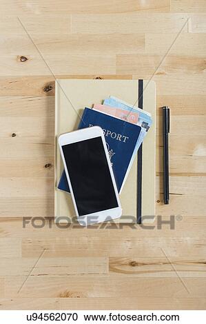 Diary, passport with paper currency, smart phone and pen on wooden table View Large Photo Image Stock Image - Diary, passport with paper currency, smart phone and pen on wooden table. Fotosearch