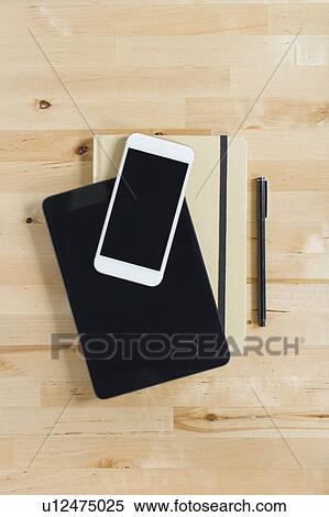 Directly above view of smart phone and personal organizers on wooden desk View Large Photo Image Stock Photography - Directly above view of smart phone and personal organizers on wooden desk. Fotosearch