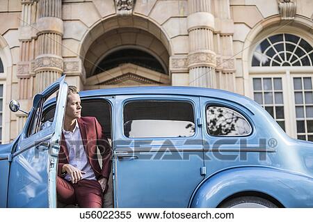 Stock Photography - Elegant man sitting in vintage car. Fotosearch