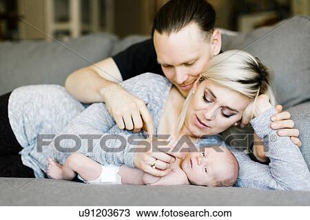 Family with one day son (0-1 months) lying on sofa View Large Photo Image Stock Image - Family with one day son (0-1 months) lying on sofa. Fotosearch