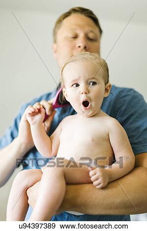 Father and baby girl (12-17 months) brushing hair after bath View Large Photo Image Stock Photo - Father and baby girl (12-17 months) brushing hair after bath. Fotosearch