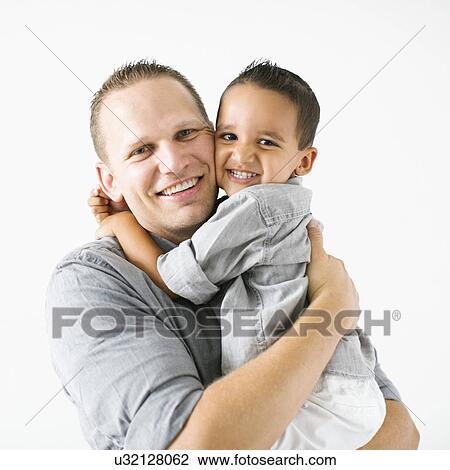 Stock Image - Father and son (2-3) embracing and smiling. Fotosearch