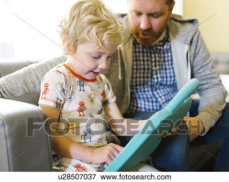 Father and son (4-5) playing with electronic toy View Large Photo Image Stock Photo - Father and son (4-5) playing with electronic toy. Fotosearch