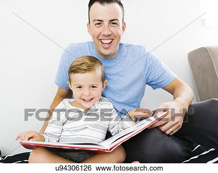 Father and son (4-5) sitting on bed and holding book View Large Photo Image Stock Photograph - Father and son (4-5) sitting on bed and holding book. Fotosearch