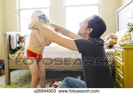 Father dressing son (4-5) in bedroom View Large Photo Image Stock Image - Father dressing son (4-5) in bedroom. Fotosearch